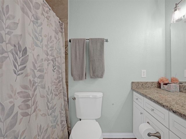 bathroom featuring a shower with curtain, baseboards, vanity, and toilet