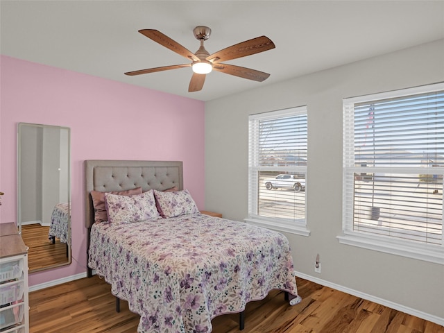 bedroom featuring a ceiling fan, baseboards, and wood finished floors