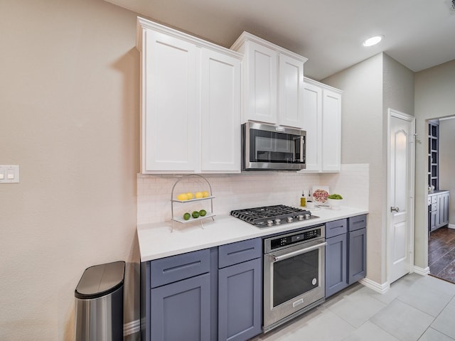 kitchen featuring appliances with stainless steel finishes, light countertops, white cabinetry, and backsplash