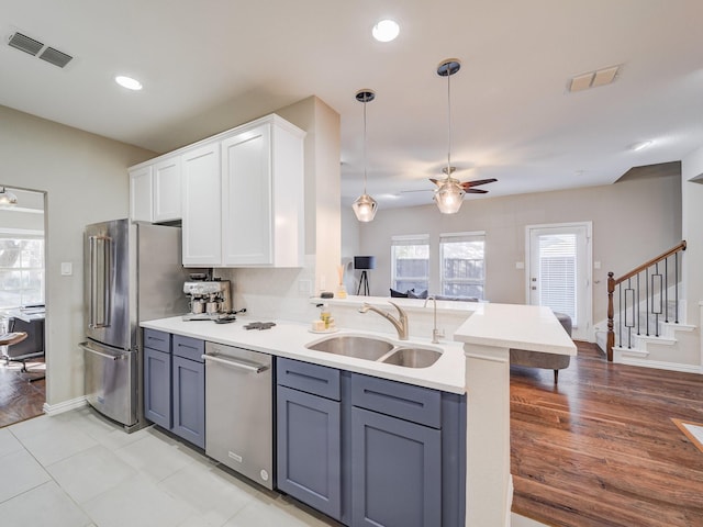 kitchen with white cabinetry, appliances with stainless steel finishes, visible vents, and a sink