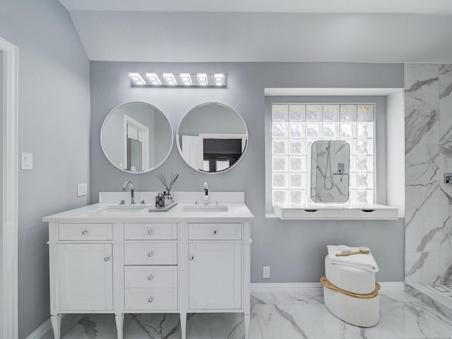 bathroom featuring marble finish floor, a sink, baseboards, and double vanity