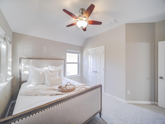 bedroom featuring carpet, lofted ceiling, a closet, visible vents, and baseboards