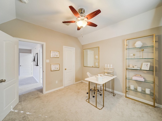 carpeted office space featuring lofted ceiling, visible vents, a ceiling fan, and baseboards