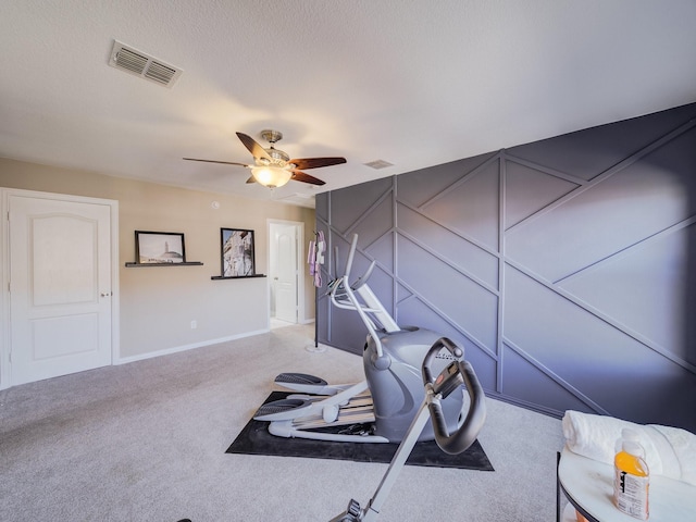 exercise area with carpet, visible vents, ceiling fan, and a textured ceiling