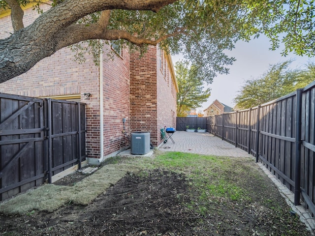 view of yard with central AC, a patio, and a fenced backyard