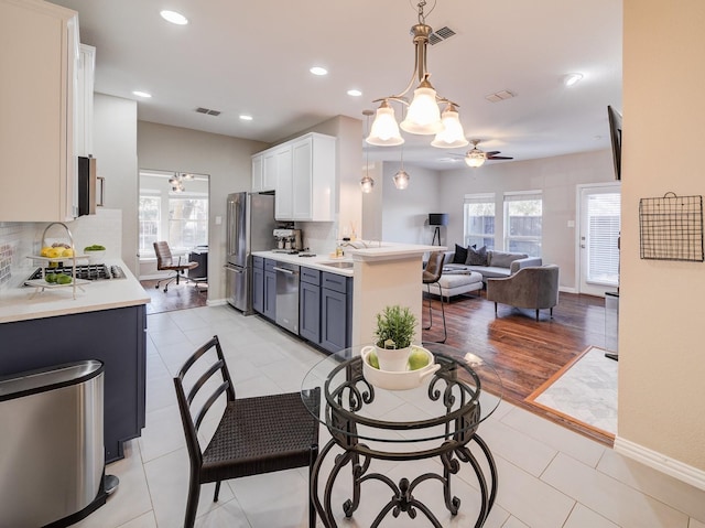 kitchen with visible vents, appliances with stainless steel finishes, tasteful backsplash, and open floor plan