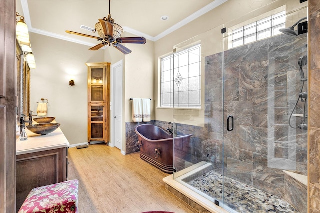 full bath featuring wood finished floors, vanity, a freestanding bath, ornamental molding, and a stall shower