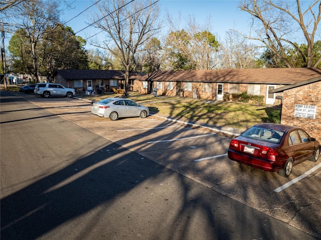 view of front of property with uncovered parking, a front lawn, and a residential view