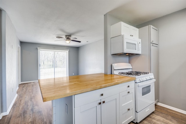 kitchen with light wood-style flooring, white appliances, a ceiling fan, baseboards, and white cabinets