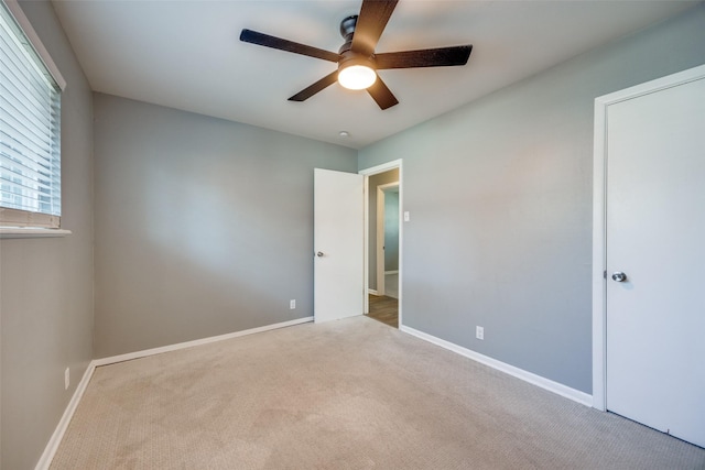 unfurnished bedroom with ceiling fan, carpet, and baseboards