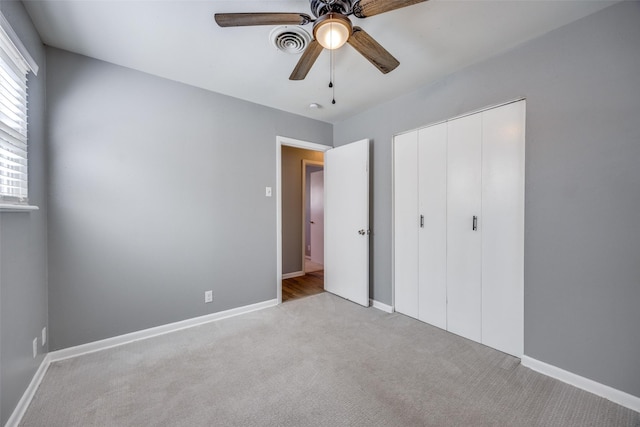 unfurnished bedroom featuring carpet floors, a closet, visible vents, and baseboards