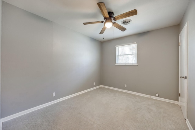 spare room with a ceiling fan, visible vents, light carpet, and baseboards