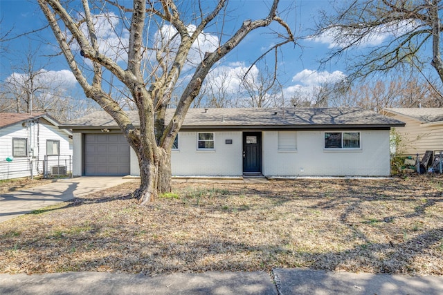 ranch-style home with a garage, brick siding, driveway, and fence