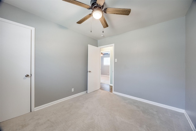 interior space with carpet floors, baseboards, and a ceiling fan