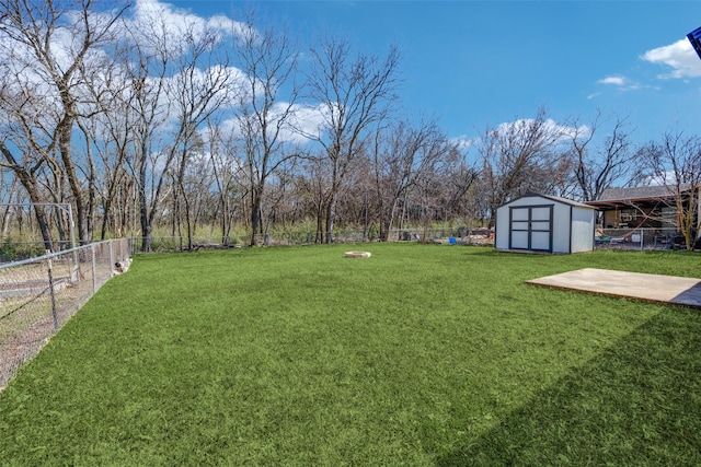 view of yard featuring an outbuilding, a fenced backyard, and a storage unit