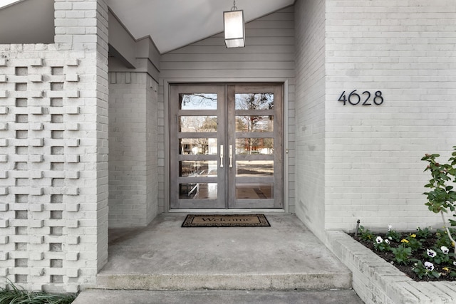 view of exterior entry with french doors and brick siding