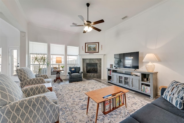 living area with a wealth of natural light, ornamental molding, wood finished floors, and visible vents