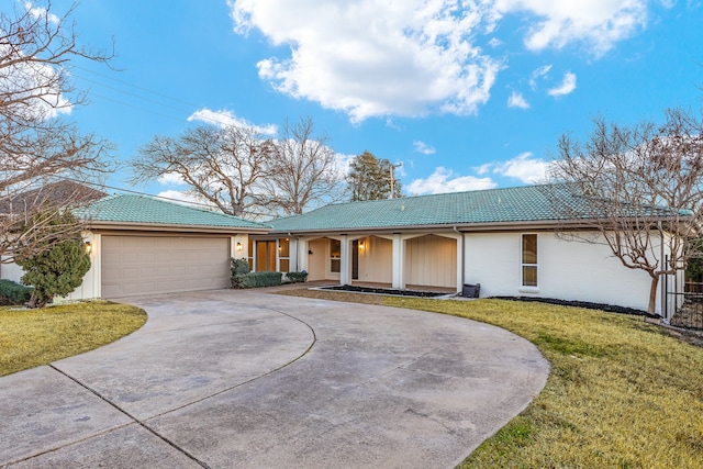 ranch-style home with a garage, a front yard, concrete driveway, and a tiled roof