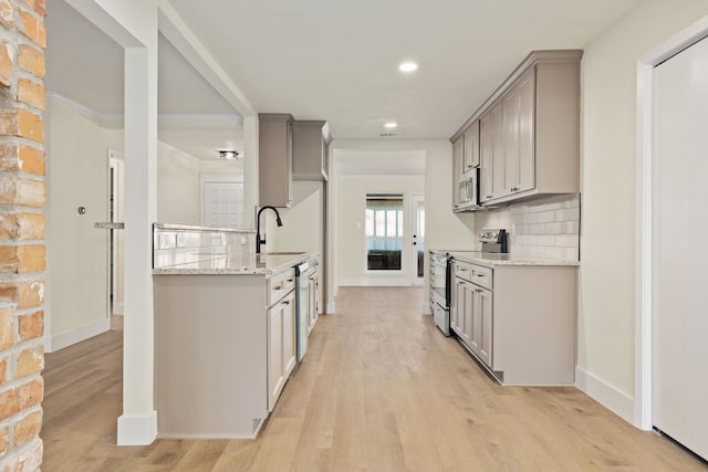 kitchen featuring appliances with stainless steel finishes, gray cabinets, and a sink