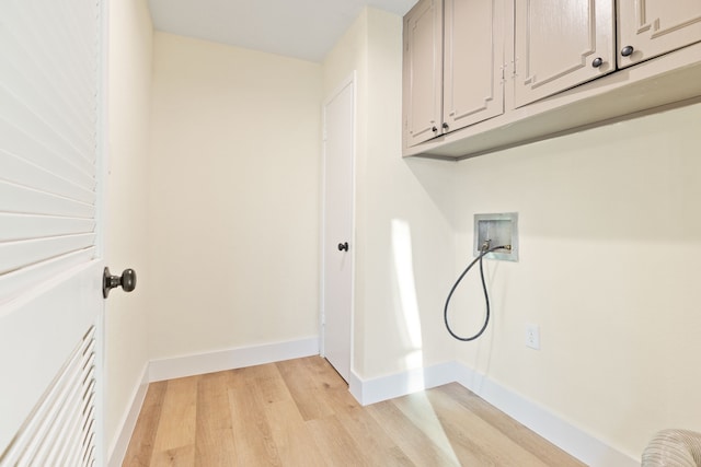 laundry room with light wood-style flooring, washer hookup, cabinet space, and baseboards