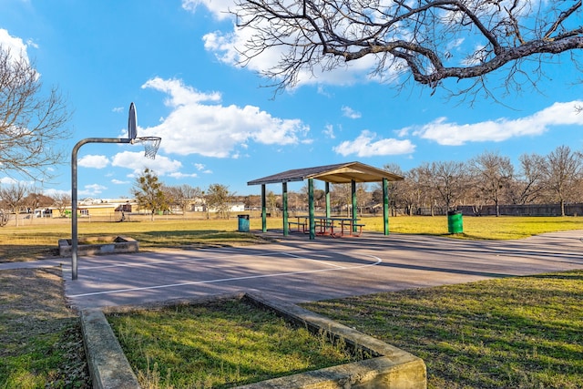 view of property's community with community basketball court and a lawn