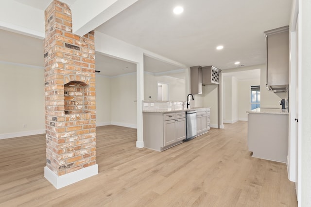 kitchen featuring recessed lighting, a sink, baseboards, dishwasher, and light wood finished floors