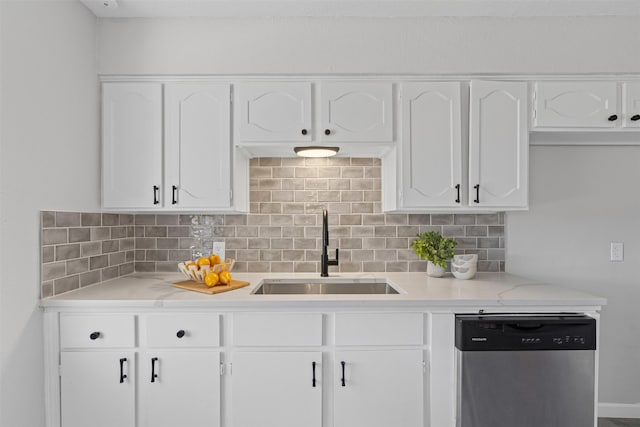 kitchen with decorative backsplash, white cabinets, dishwasher, and a sink