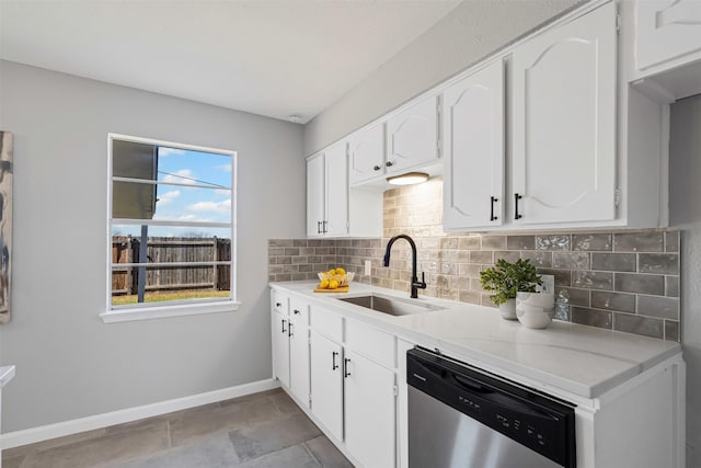 kitchen with a sink, tasteful backsplash, white cabinets, and stainless steel dishwasher