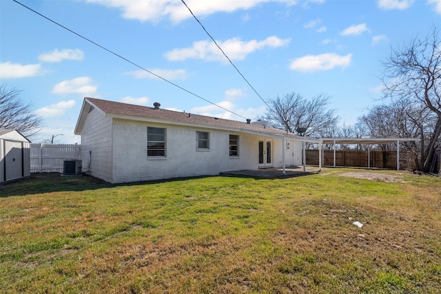 back of property with french doors, brick siding, a yard, central air condition unit, and a fenced backyard