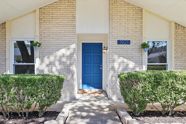 entrance to property featuring brick siding