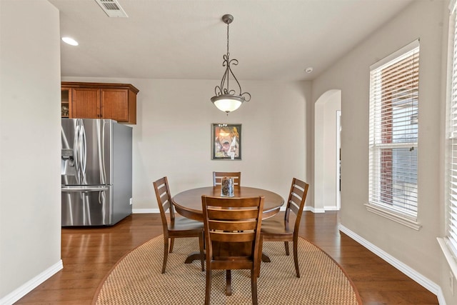 dining room featuring visible vents, arched walkways, baseboards, dark wood-style floors, and recessed lighting