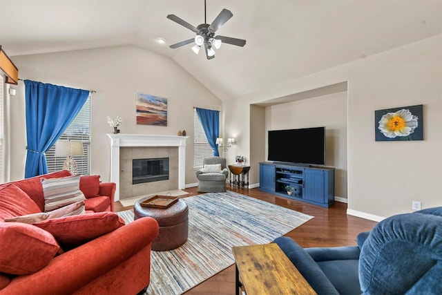 living area featuring a fireplace, lofted ceiling, ceiling fan, wood finished floors, and baseboards