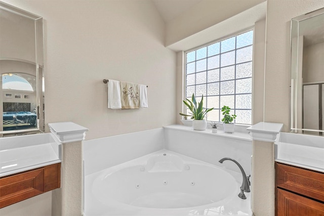 full bathroom with a jetted tub and vanity