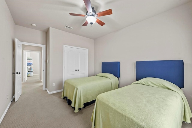 bedroom with a closet, visible vents, light carpet, ceiling fan, and baseboards