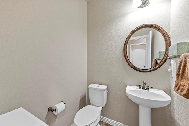 half bath featuring a sink and toilet