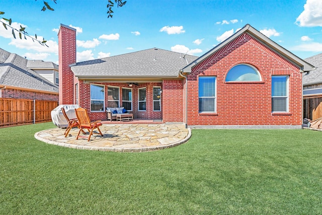 rear view of property with brick siding, a yard, a chimney, a patio area, and fence