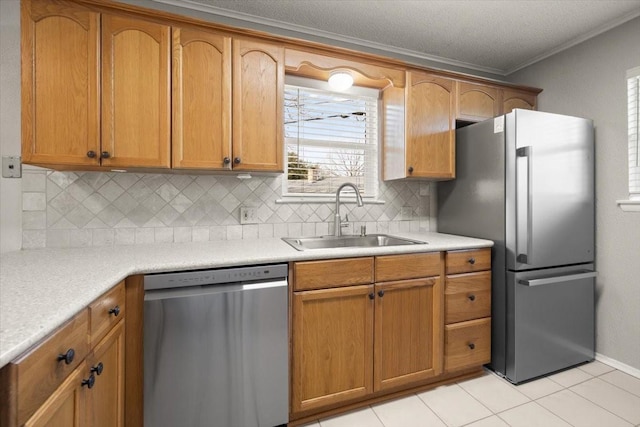 kitchen featuring decorative backsplash, ornamental molding, stainless steel appliances, light countertops, and a sink