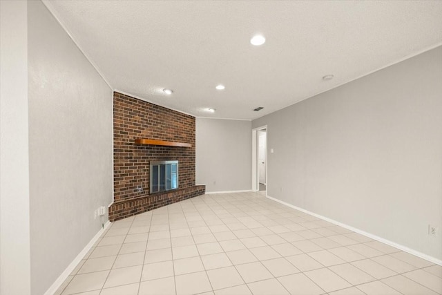 unfurnished living room with light tile patterned floors, recessed lighting, a brick fireplace, a textured ceiling, and baseboards