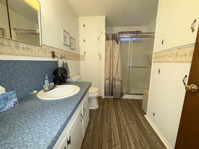 full bathroom with vanity, a stall shower, wood finished floors, and toilet