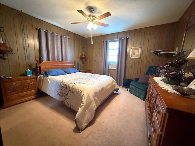 carpeted bedroom featuring wood walls and ceiling fan