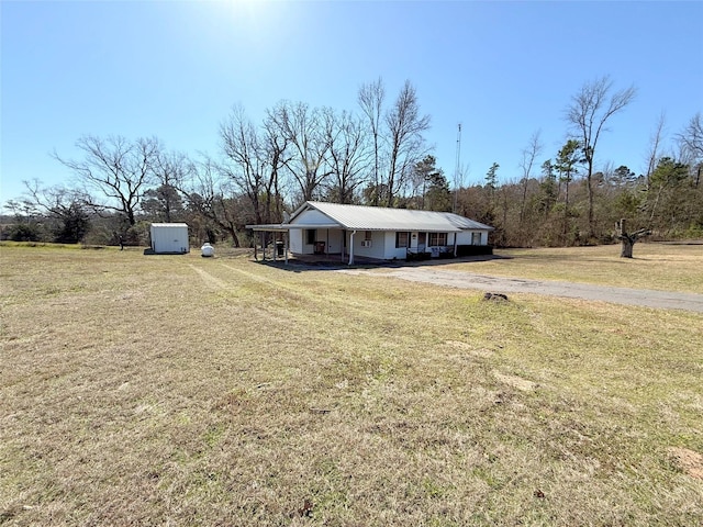 view of front of property featuring an outbuilding, a front lawn, a porch, and a storage unit