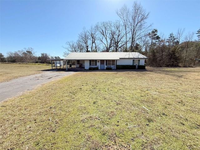 single story home with a carport, a front yard, metal roof, and aphalt driveway