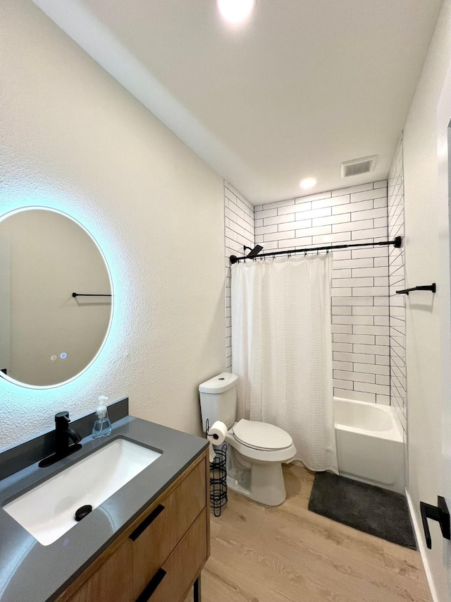 full bath featuring toilet, wood finished floors, vanity, visible vents, and shower / bath combination with curtain