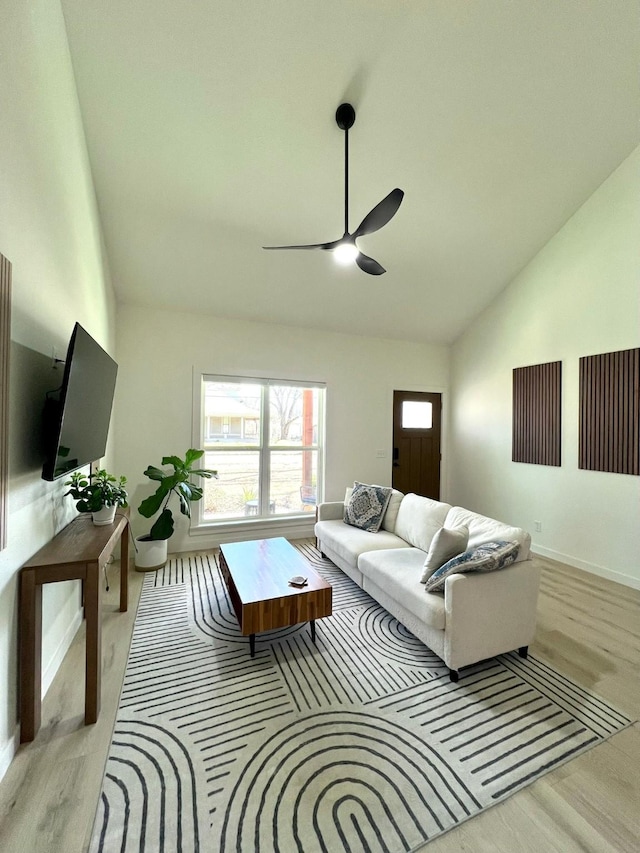 living area with lofted ceiling, wood finished floors, a ceiling fan, and baseboards