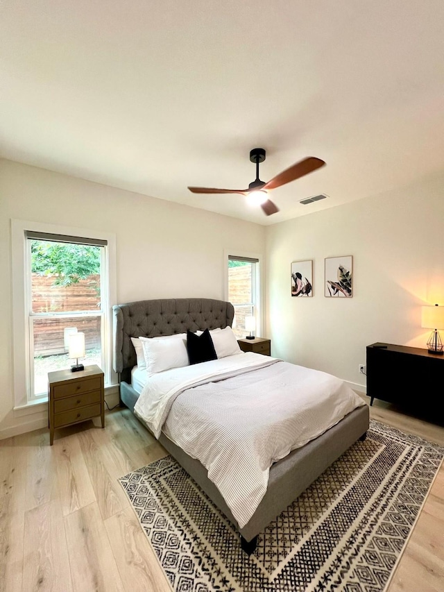 bedroom with visible vents, ceiling fan, light wood-style flooring, and multiple windows