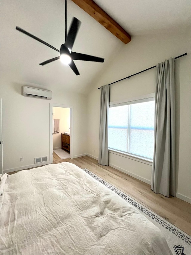 unfurnished bedroom featuring visible vents, connected bathroom, lofted ceiling with beams, a wall mounted air conditioner, and light wood-style floors