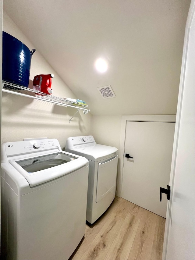 laundry area featuring washer and dryer, laundry area, visible vents, and light wood-style flooring