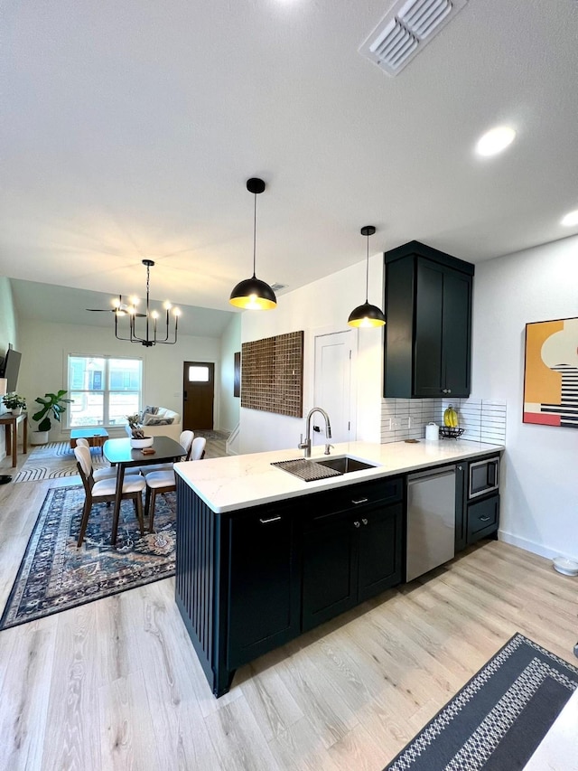 kitchen with dark cabinetry, visible vents, stainless steel appliances, and a sink