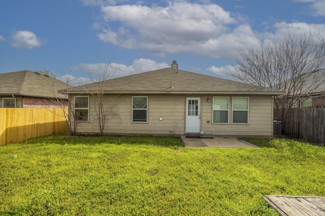 back of house featuring a lawn, a fenced backyard, and a patio area