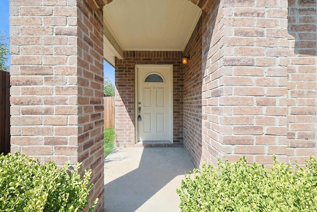 entrance to property featuring brick siding